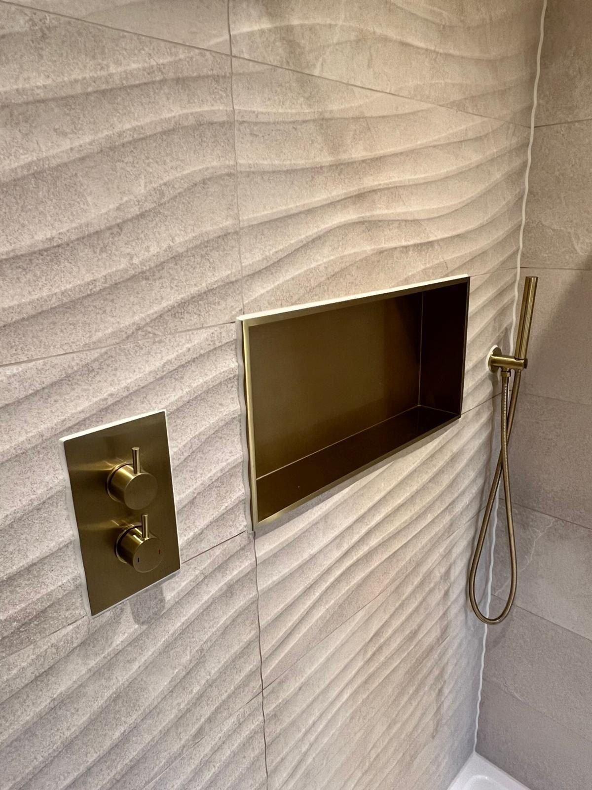 En suite with a brushed brass shower niche