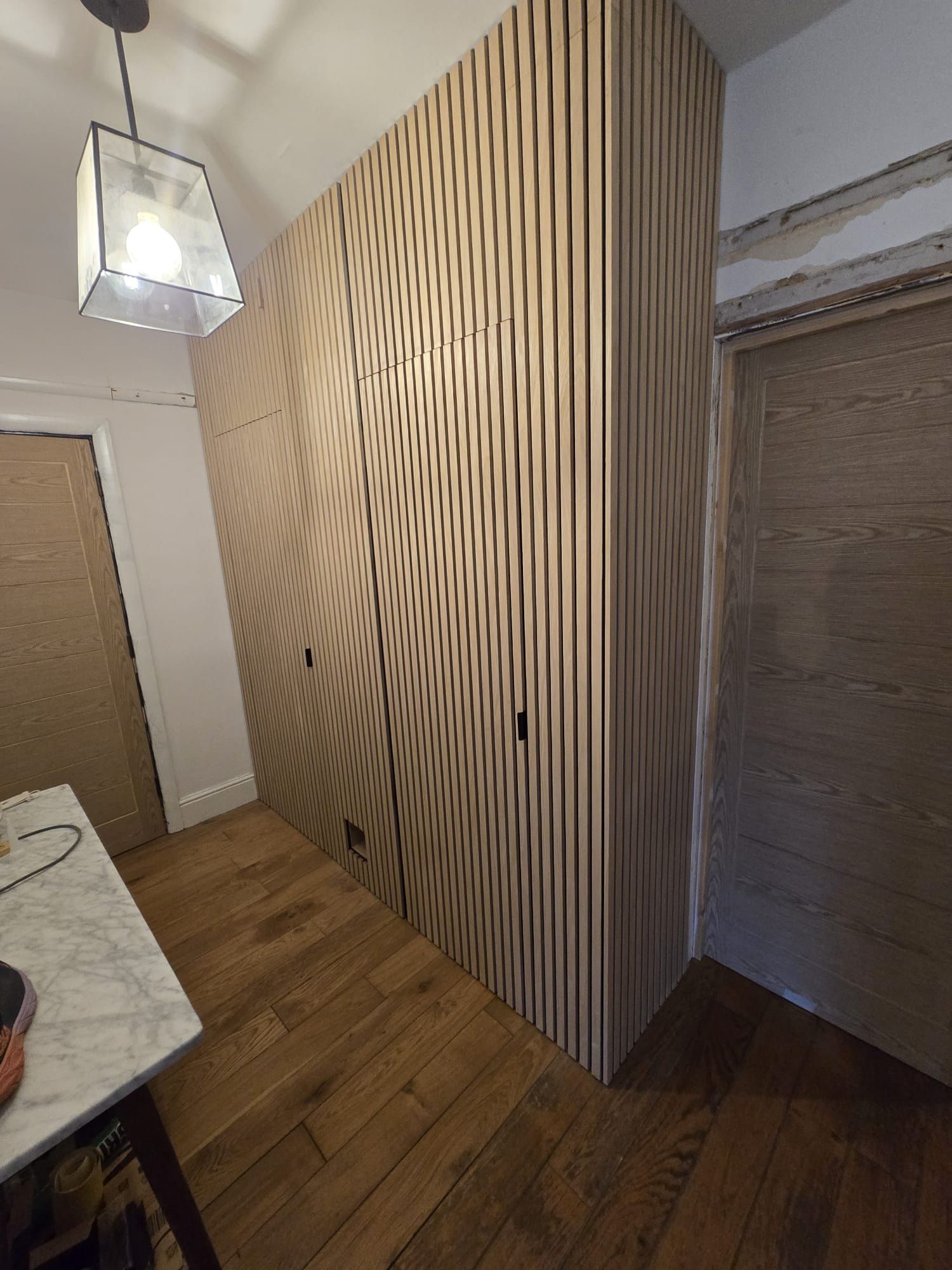 Refurbished hallway with an oak slatted feature wall