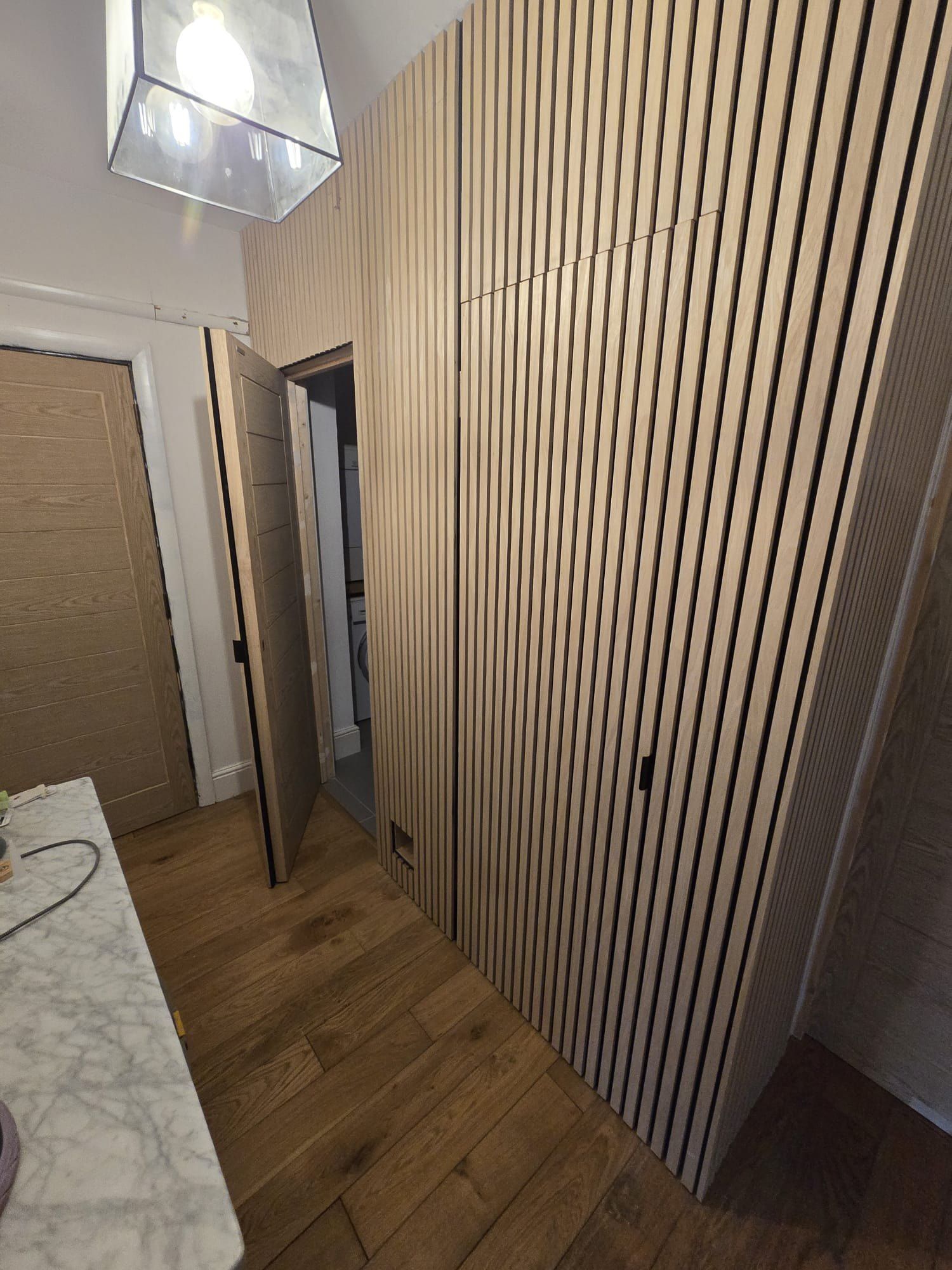 Oak slatted wall with a hidden door