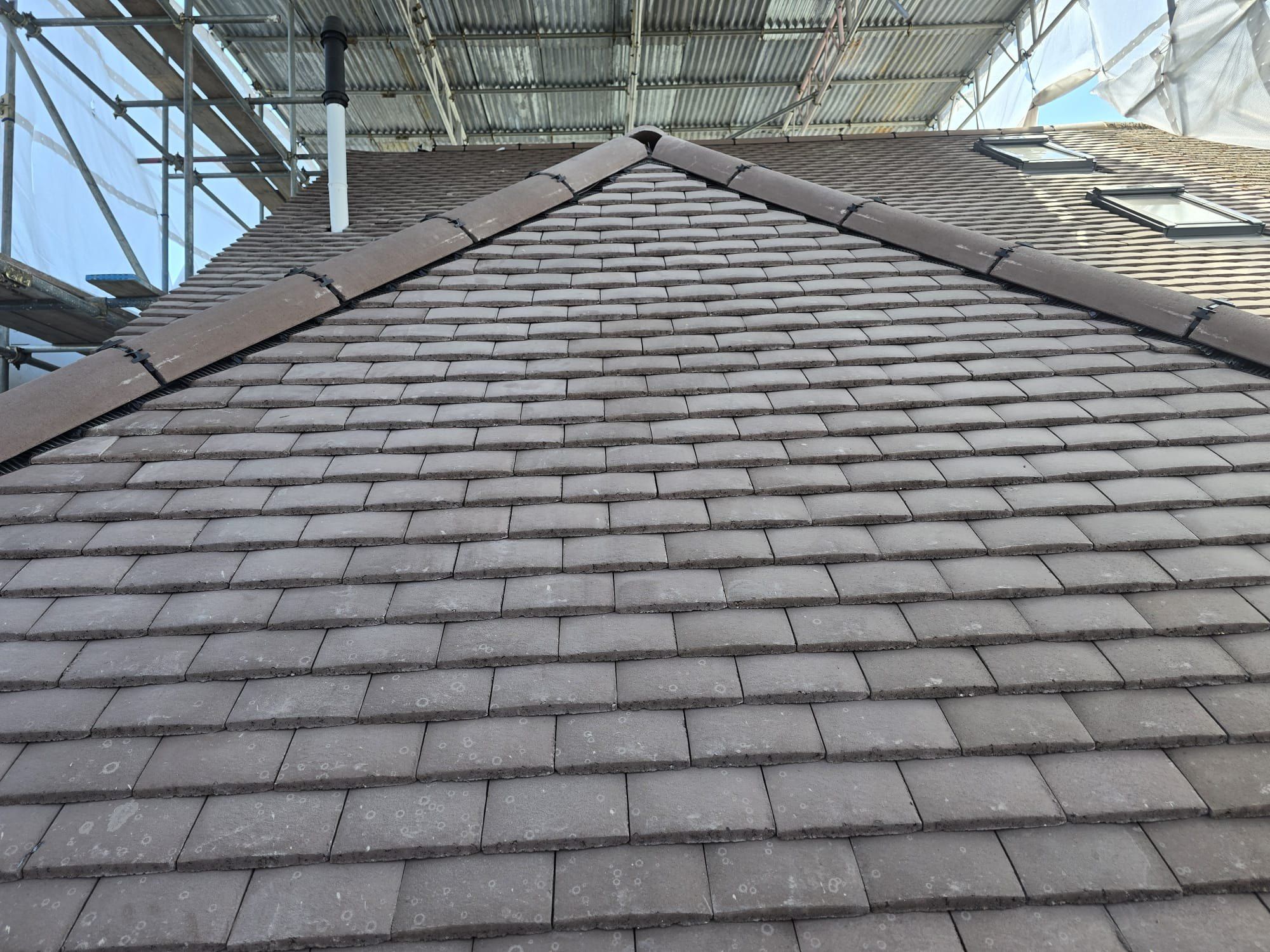 Newly tiled hip roof with crisp ridge lines